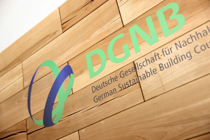 grüner DGNB-Schriftzug auf Hollpanele an einer Wand