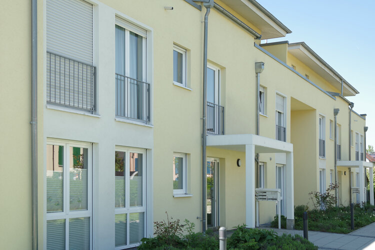Neue Mehrfamilienhäuser mit gelber Fassade in einer Wohnsiedlung