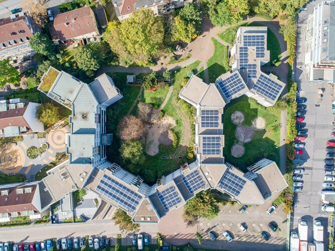 Solardächer von in Halbkreisen verbundenen Mehrfamilienhäusern, aufgenommen von oben