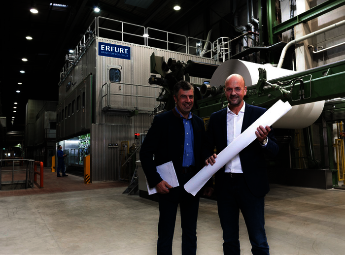 Fit für die Zukunft: Henrik und Martin Erfurt (v.l.n.r.) vor der kürzlich modernisierten Papiermaschine „PM 5“.