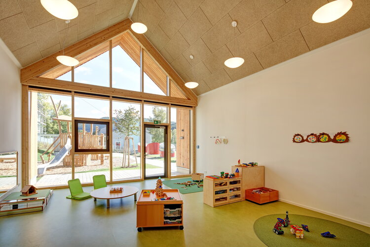Gruppenraum in einer Kindertagesstätte Albstadt mit Spielzeug, Holzbauweise, Glasfassade zum Spielplatz, Giebelbereich verglast