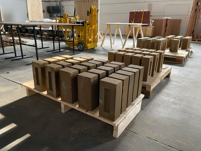 Gepresste Lehmsteine auf einer Palette in der Forschungswerkstatt von Bauhaus Erde