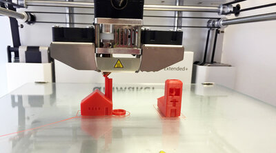 3D-Drucker: zwei kleine Modellhäuser in rot sind entstanden