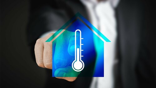 Grafik-Collage: Temperatur-Thermostat in Hausumriss, dahinter ein Mann, der auf die Collage zeigt