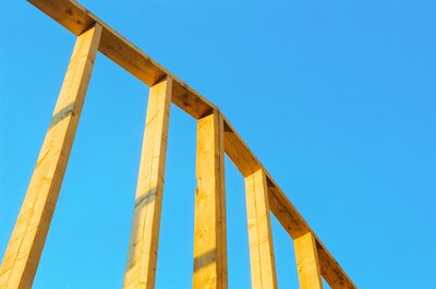 Holzrahmenkonstruktion einer Fassade vor blauem Himmel