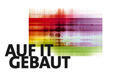 Logo Wettbewerb "Auf IT gebaut – Bauberufe mit Zukunft": Schrift "Auf IT gebaut" links unten, dahinter Farbverlauf in Rot-, Gelb-, Lila-, Hellblau-, Grünton auf angedeutetem Milimeterpapier