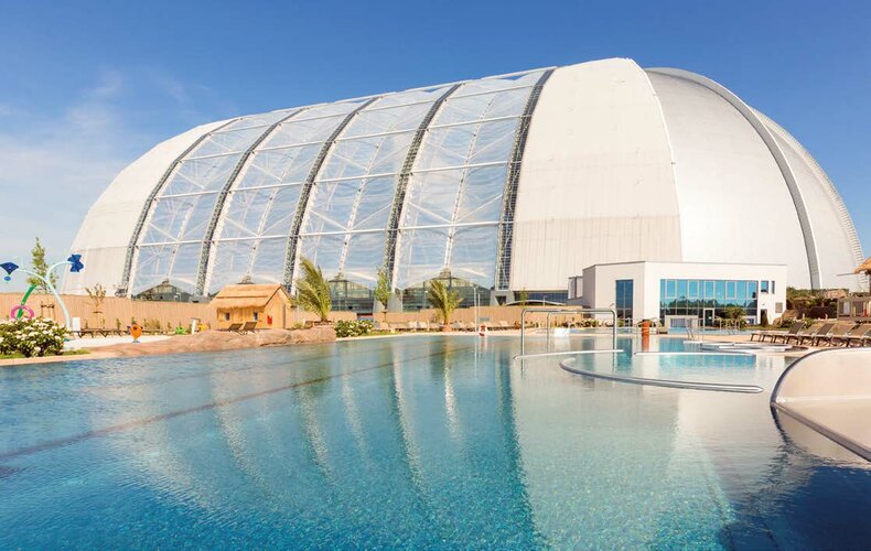 Der Dome von Tropical Islands ist eine der weltweit größten freitragenden Hallen. Der Außenbereich „Amazonia“ bietet neben mehreren Wasserattraktionen auch eine große Liegewiese sowie Sport- und Spielbereiche auf insgesamt 35.000 m² Fläche.