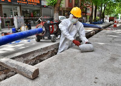 Straßenbauarbeiter beseitigt in Schutzkleidung Asbest