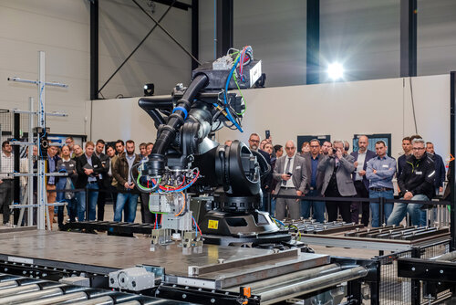 Zuschauer bei der Eröffnung des Carbonbetontechnikums betrachten die Robotertechnik, mit der Bauteile aus Carbonbeton automatisiert gefertigt werden