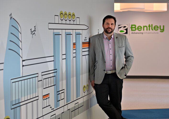 Alexandre Vallières, Director, AI Strategy and Research, bei Bentley System, an einer Wand lehnend ineinem Büroraum