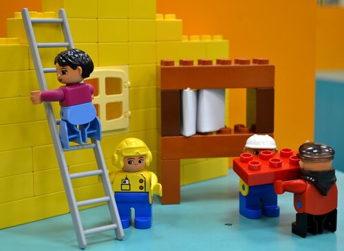 Spielfiguren als Bauarbeiter auf einer Baustelle
