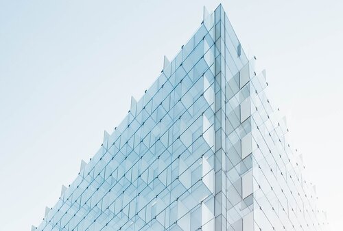 Aufnahme der Glasfassade eines Bürogebäudes aus der Froschperspektive