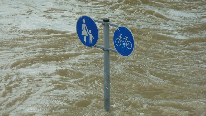 Verkehrsschilder auf überfluteter Straße