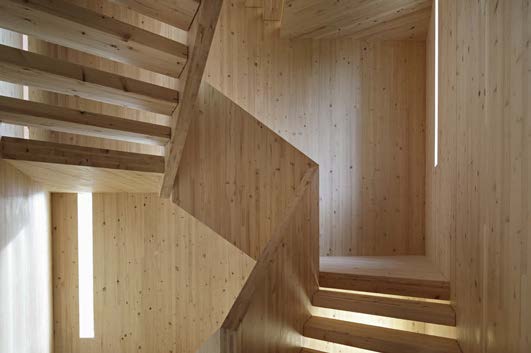 Wände aus Brettsperrholzelementen formen den Holzturm. Wandschlitze belichten das Treppenhaus und erlauben rundum Ausblicke beim Aufstieg. Die 1,10 m breiten Treppenläufe schmiegen sich mit Wangen und Podesten in die Dreikant-Röhre.